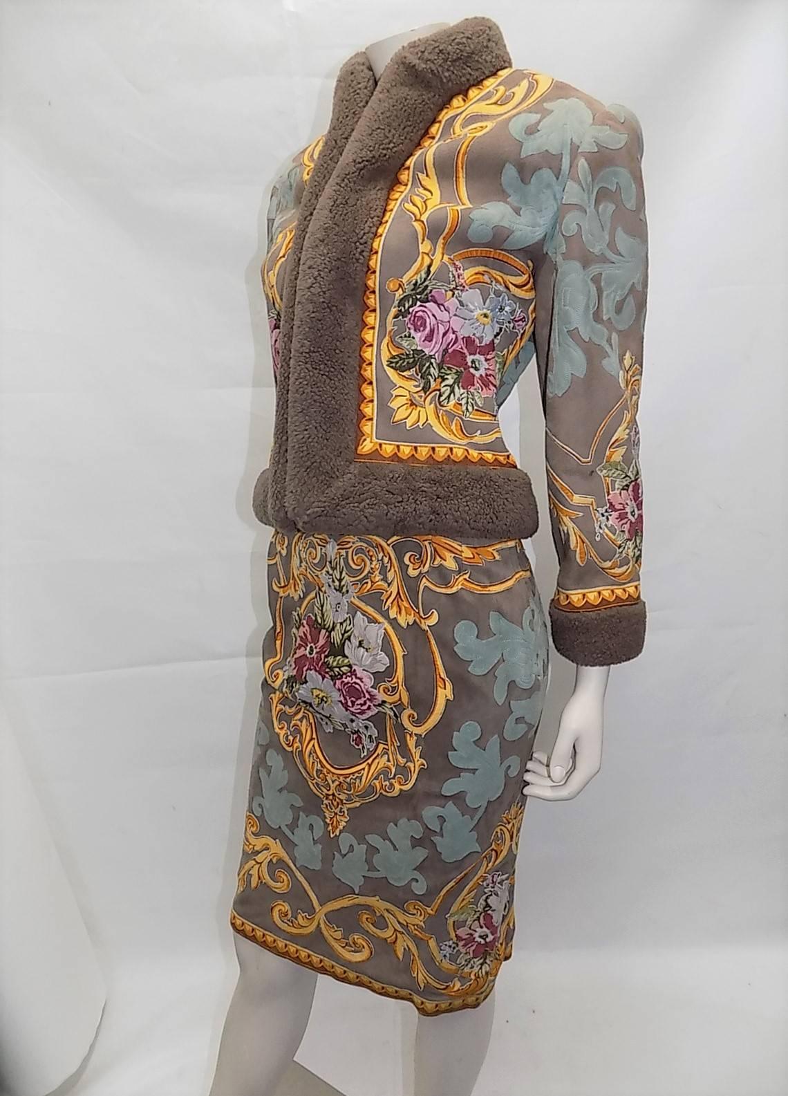 Absolutely stunning  shearling skirt suit from Valentino is made of tan suede with hand painted appliques sewn  throughout depicting flowers and scrolling patterns. Jacket has shearling trim along cuffs, collar, and center front as well as center