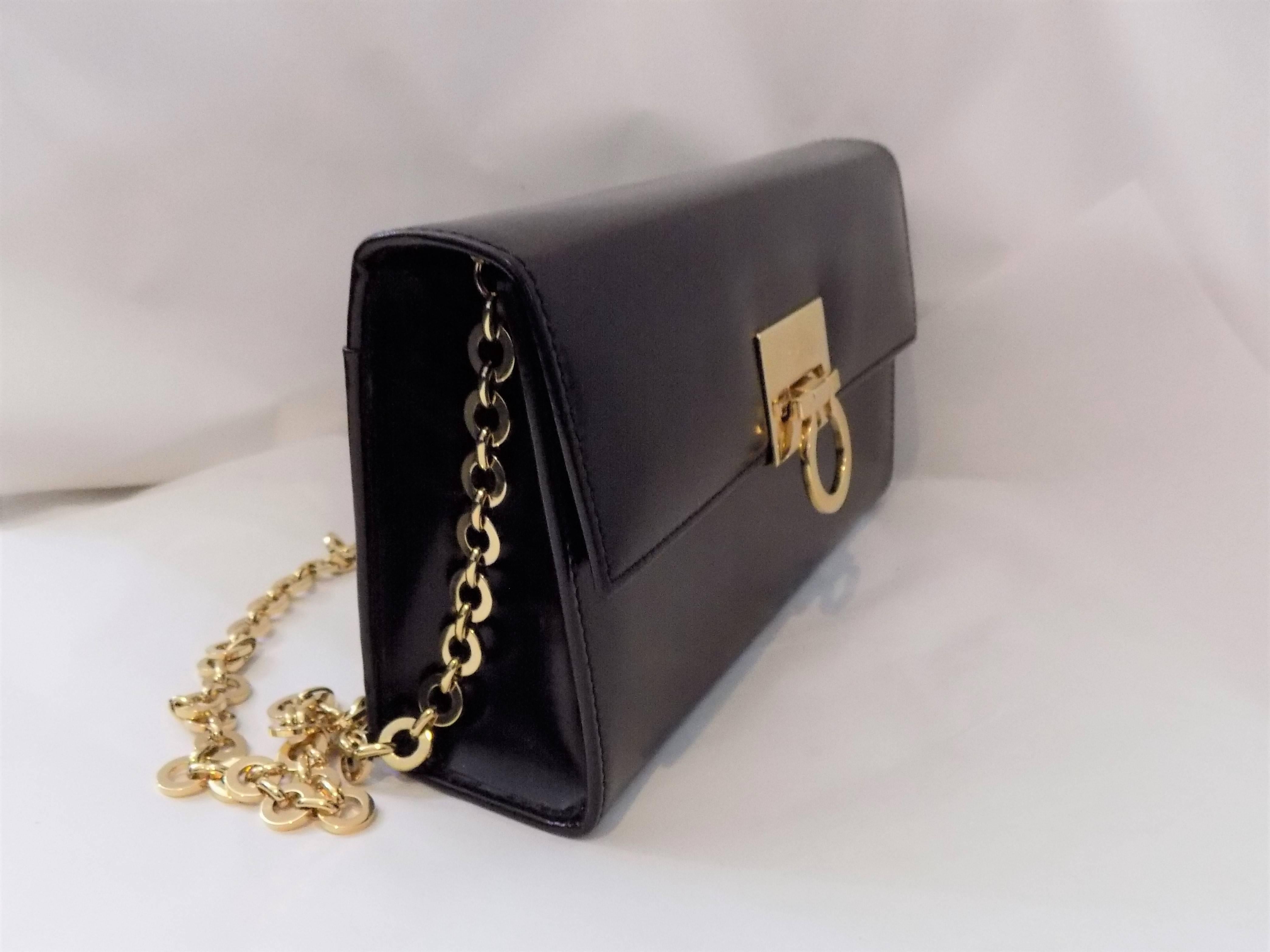 Structured  polished Black calf leather  shoulder bag from Salvatore Ferragamo featuring a Gold-tone chain  removable houlder strap, a holdover top with snap closure,Gancio lock  a gold -tone logo plaque and an internal slip pocket. 
Like new