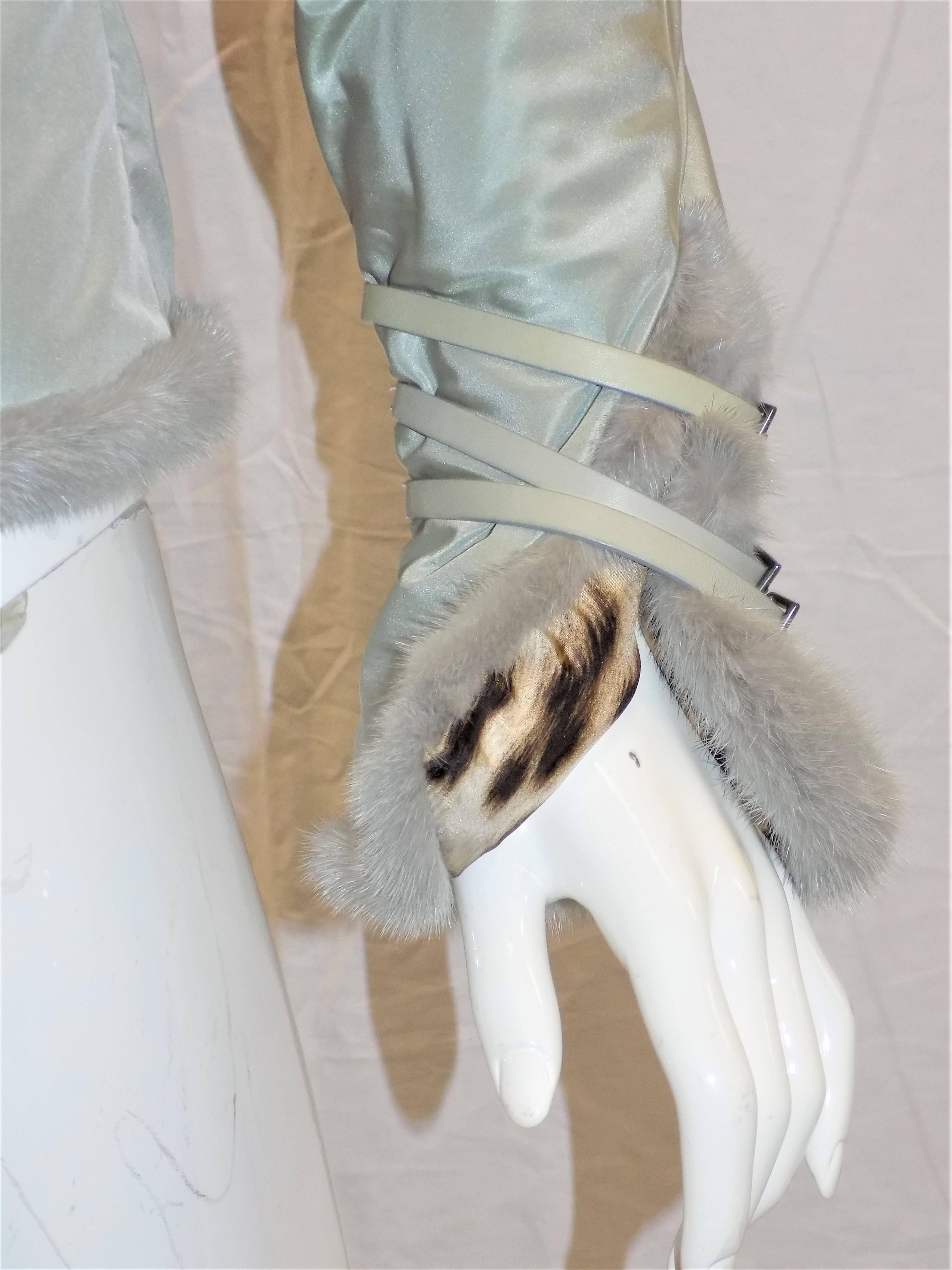Guaranteed Authentic! Roberto Cavalli Grey Roberto Cavalli silk puffer leather and fur-trimmed jacket with rounded collar, long sleeves and concealed zip featuring sash tie belt closures at center front and sleeves Signature Leopard print lining.