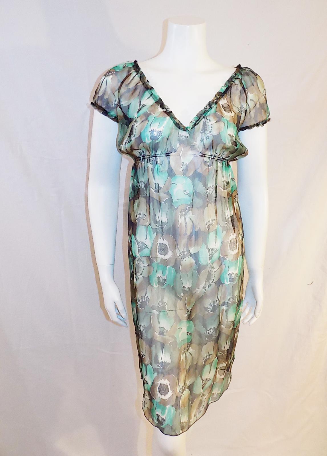 Pretty and easy to wear pristine condition Prada silk chifon floral dress. Elastic sleeves , neckline and midriff , Perfect summer dress. It needs  lining or body suit under since it is see trough
Size 4