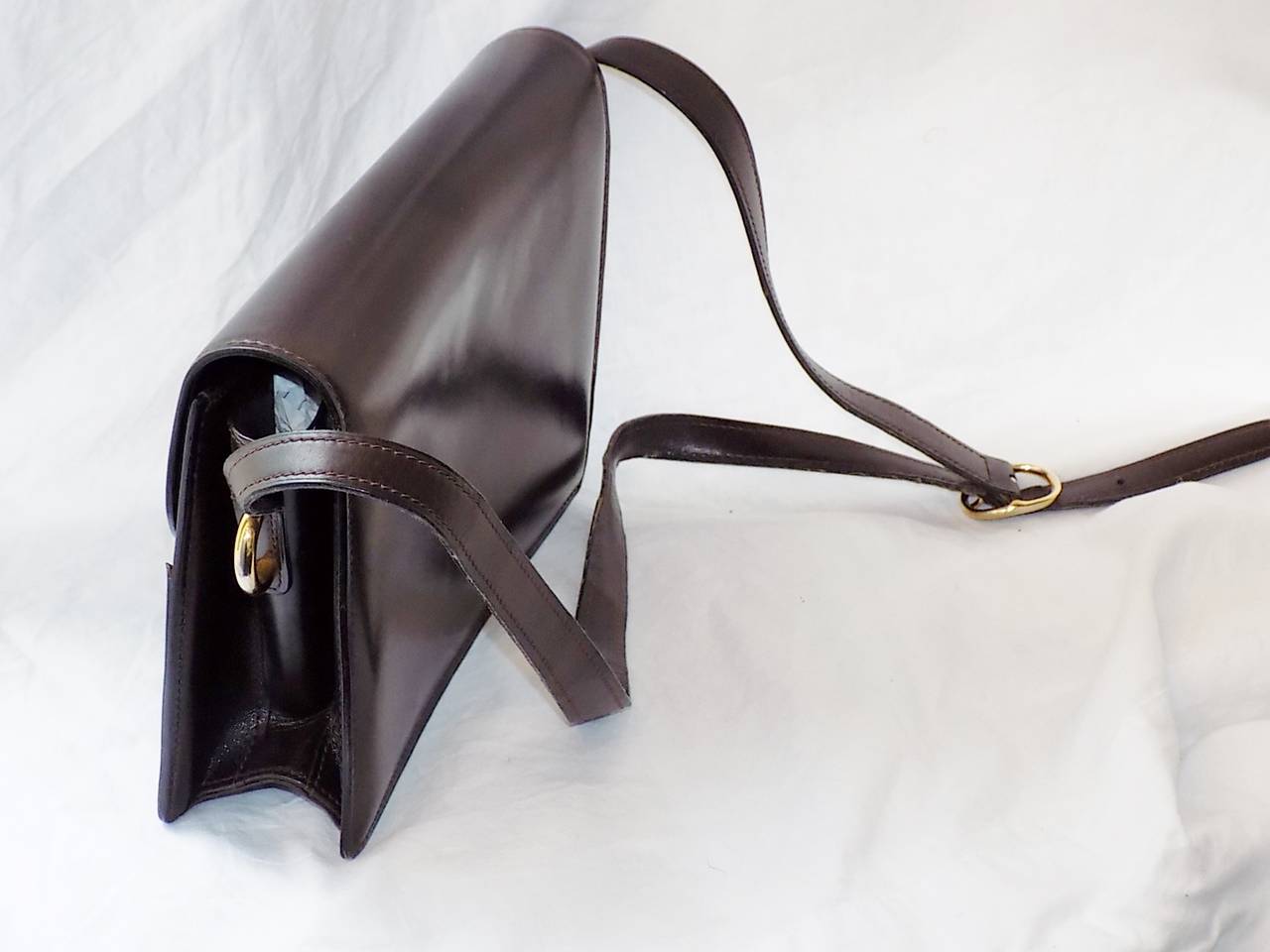Chocolate brown leather bag by Gucci. Circa 1970's in excellent condition. Collectors piece. . Two tone front buckle closure . Structural bag and very architectural design, Leather lined with two pockets inside one zipered and one open.. Bad