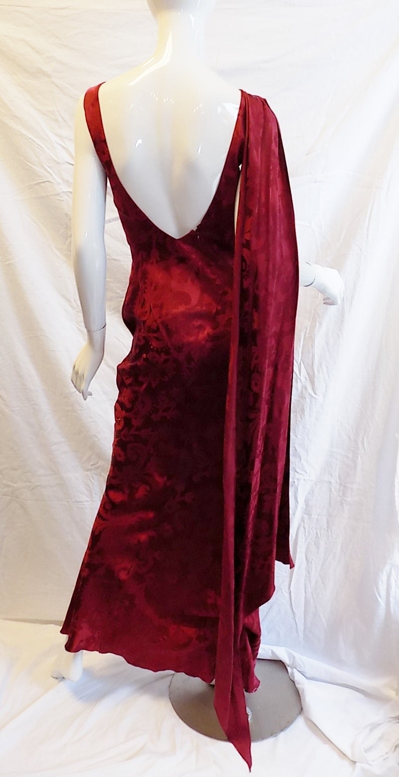 Printed silk new with tag Christian Dior vintage gown  featuring: Asymmetrical front cutouts , front deep slit, and long one shoulder drape. Retail price is still attached $2445. 
Size 40
bust 36