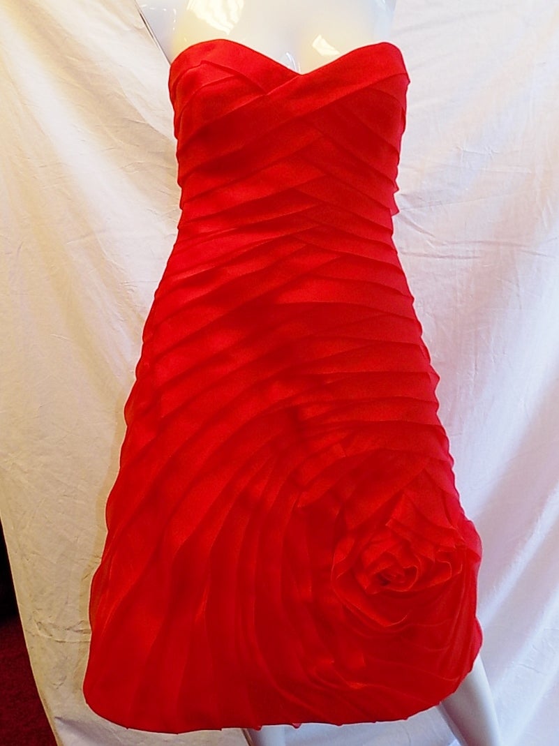 Framboise red . Sweetheart neckline; strapless. Flower pleat detail. Pure silk. Dry clean only. Imported of domestic material. This gorgeous number is a subtle approach Garden  theme, thanks to strategic pleats that form an almost subliminal rose