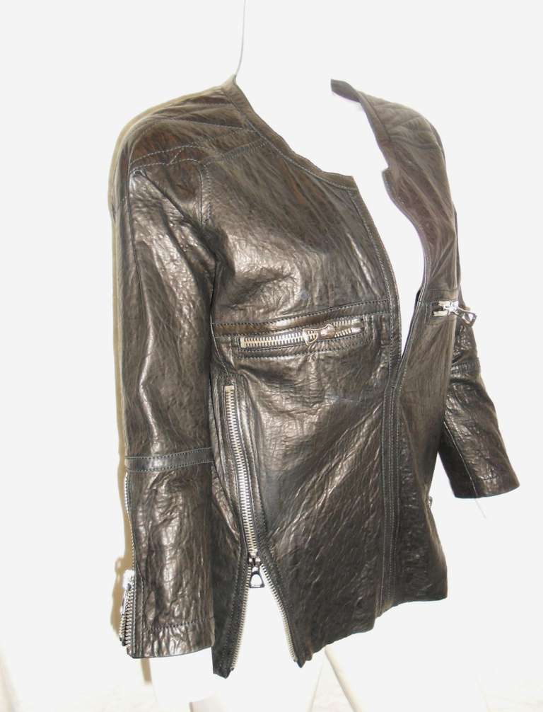 Supple lambskin leather collarless open  front blouse/ jacket with quilted shoulders.   Detailed with functional zippers at front  chest pockets, sleeves and decorative sides  . Amazing piece .
Like the designer herself, the Isabel Marant girl is