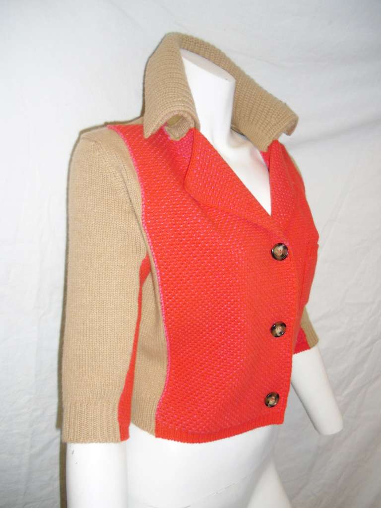 Fabulous in every way and for all seasons. ! Bright orange and tan Prada cropped cashmere  knit  cardigan jacket Three large front button down closure. one patch pocket front detail/ 3/4 sleeves. Great casual item. Doubled collar with shearing.