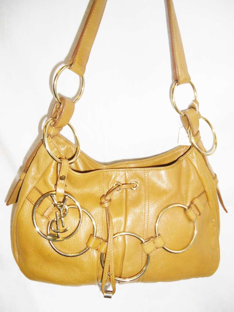 Great size day bag!!. Lite brown color Hobo style. Middle snap closure, Bag Features three large rings at the front , Large rings connecting  shoulder strap to the bag and  removable YSL logo  pendant . Lined in Dark brown satin. Shoulder strap is