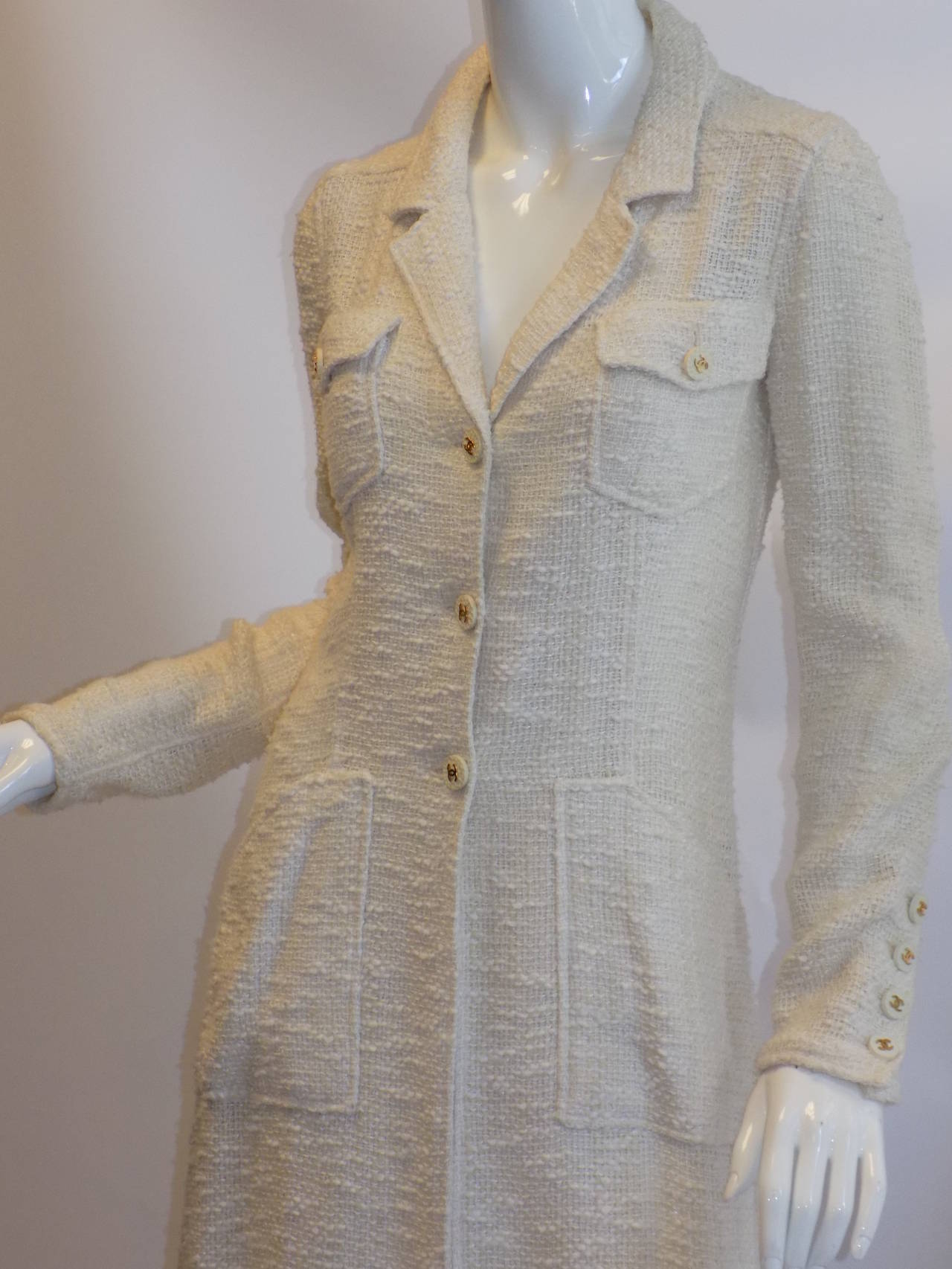 Spectacular Chanel winter white Coat- duster. Pristine condition. Woven buckle , not lined. Notched collar. Three large front button closure.  Back vent. Long sleeves with cuff buttons. Versatile piece. Truly beautiful.  
Size 6 
Bust 36