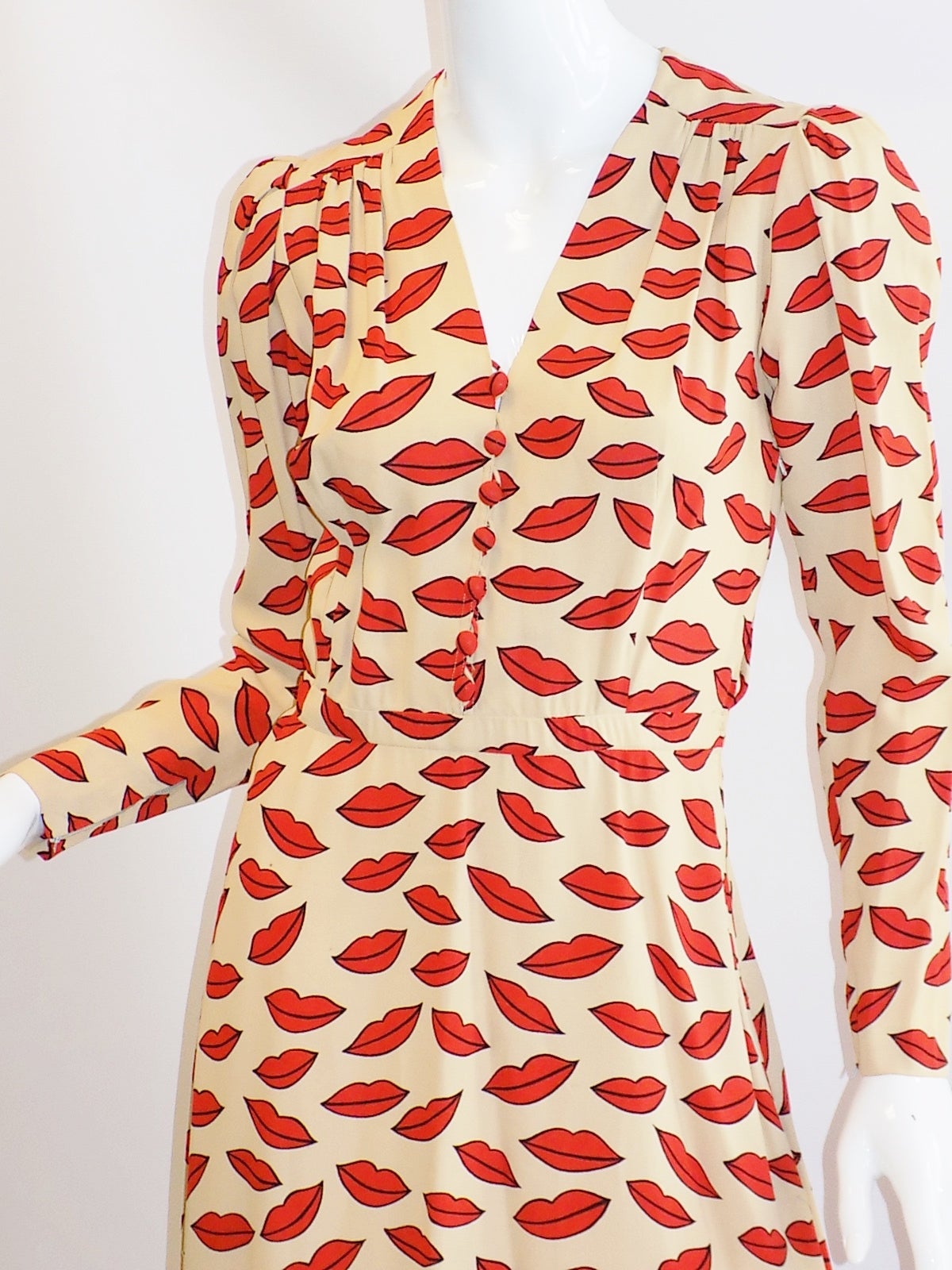 An Yves Saint Laurent 'Lips' print dress, circa 1971, Rive Gauche labelled and size 38, of Ivory  crêpe with zips to cuffs, Side zipper and front loops with covered buttons.  Small size 36. 
Bust 36: waist 26/ Length from the back of the beck to