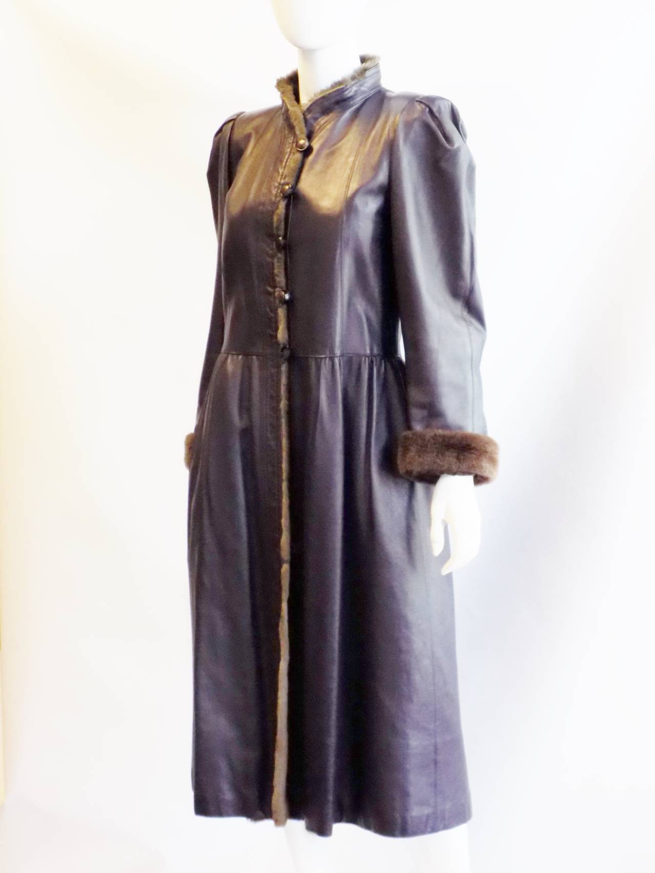 Eggplant   color very soft leather vintage YVES SAINT LAURENT coat. Sheered beaver lining . Front closure with wood buttons. Pristine condition. Please note that the only flaw on this coat is that  one button button is missing middle wood .