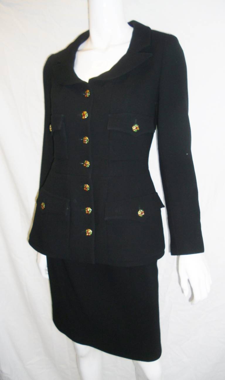 Evergreen and and aways chic black classic Chanel skirt suit with gripoix buttons. . Black lite wool with four front pockets , beautiful  collar  and straight skirt.  Design that will never go out of style. Lined in silk with gold chain at the hem. 
