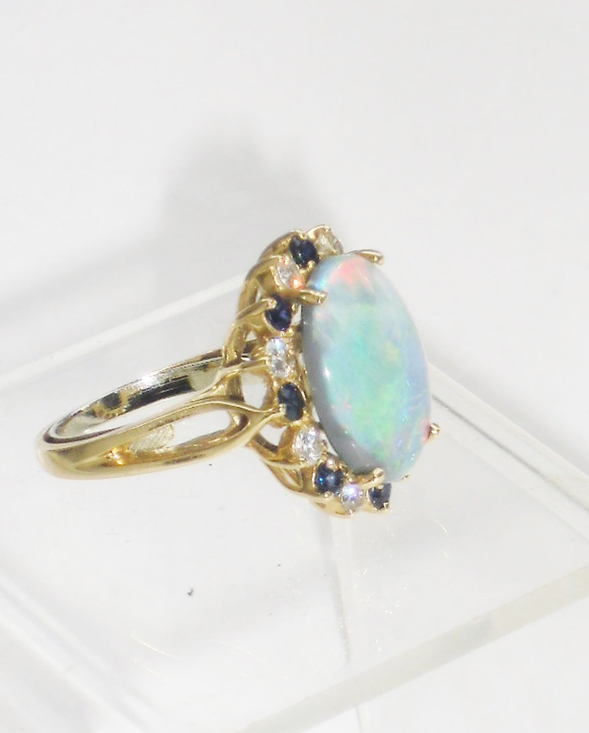 Vintage Beautiful oval Jelly Fire opal ring set with diamonds and Sapphires. Oval shape in yellow gold.  Circa 1950
Sz 7