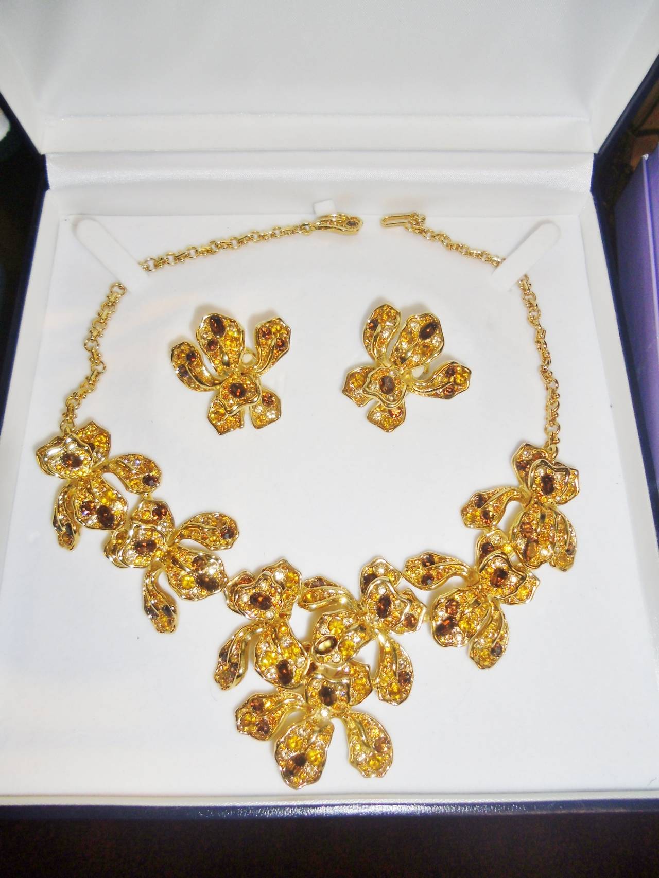 Beautiful set by Kenneth Lane. Circa 1990's. Orchid silhouette. Cubic Zirconia details.Gold tine rhodium.  Clio on earrings approx 1.5 ' wide and 1.5