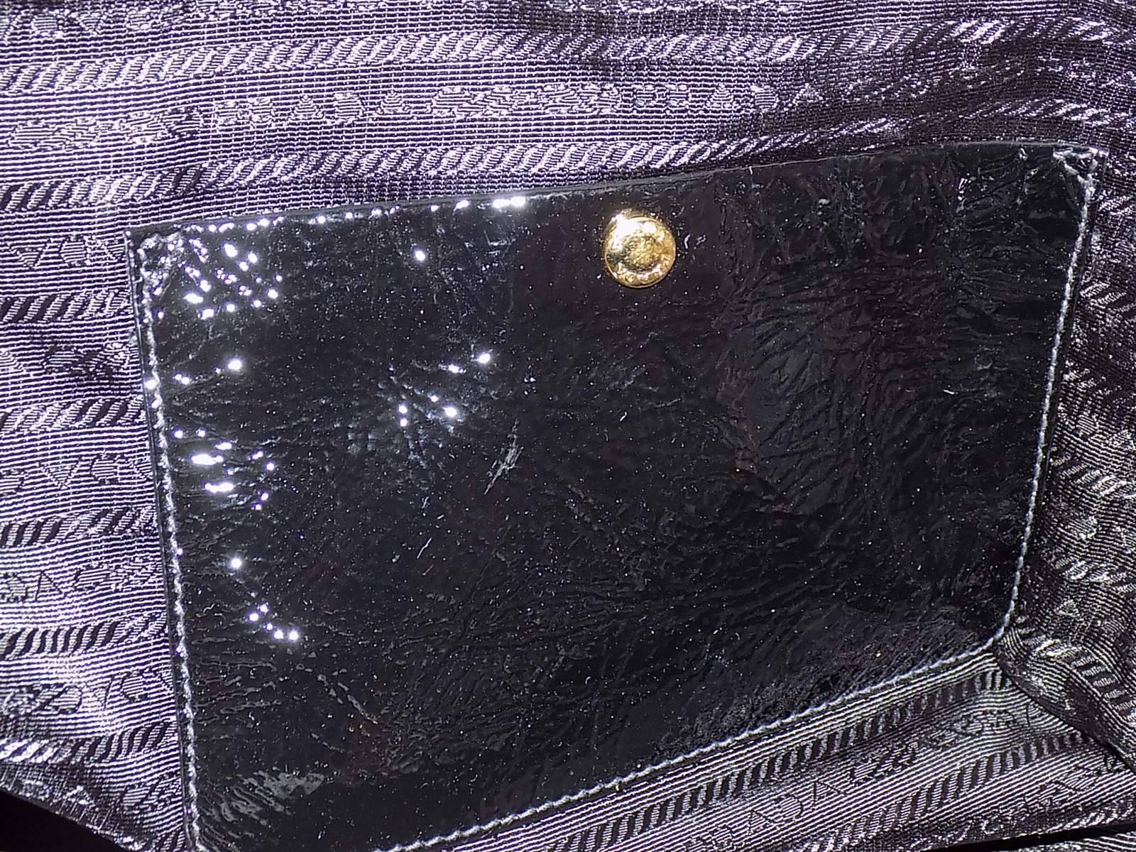 This gorgeous Prada Bauletto Bowler bag is sure to turn heads. Unique crinkled Vintage soft patent leather . This rolled top handle bag has a dome shape with a zipper closure that ends with a push-clasp side lock. A Prada gold tone logo  logo  metal