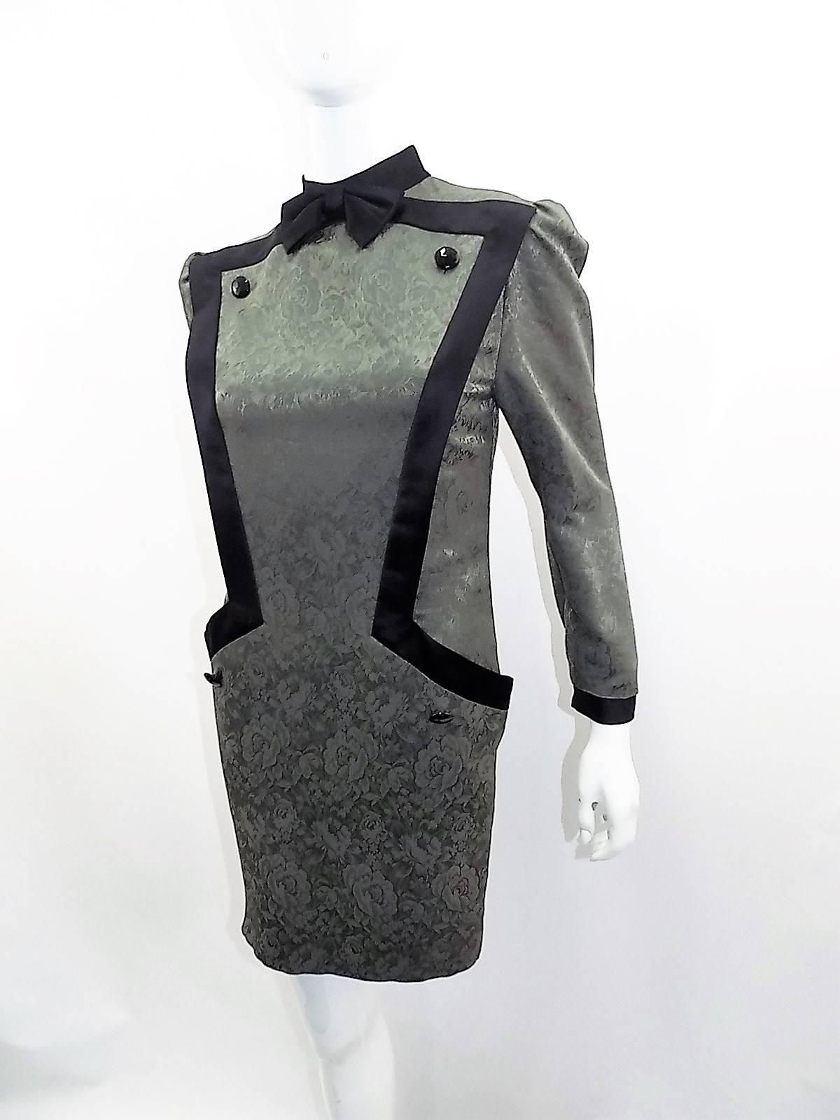 Circa late 1960's Vintage Nina Ricci dress .Wool and silk blend JACQUARD in satin finish. sage/ grey color with black details. Featuring front inserted pockets concealed by design, large black buttons and bow at the neckline. 
Zipper back closure.