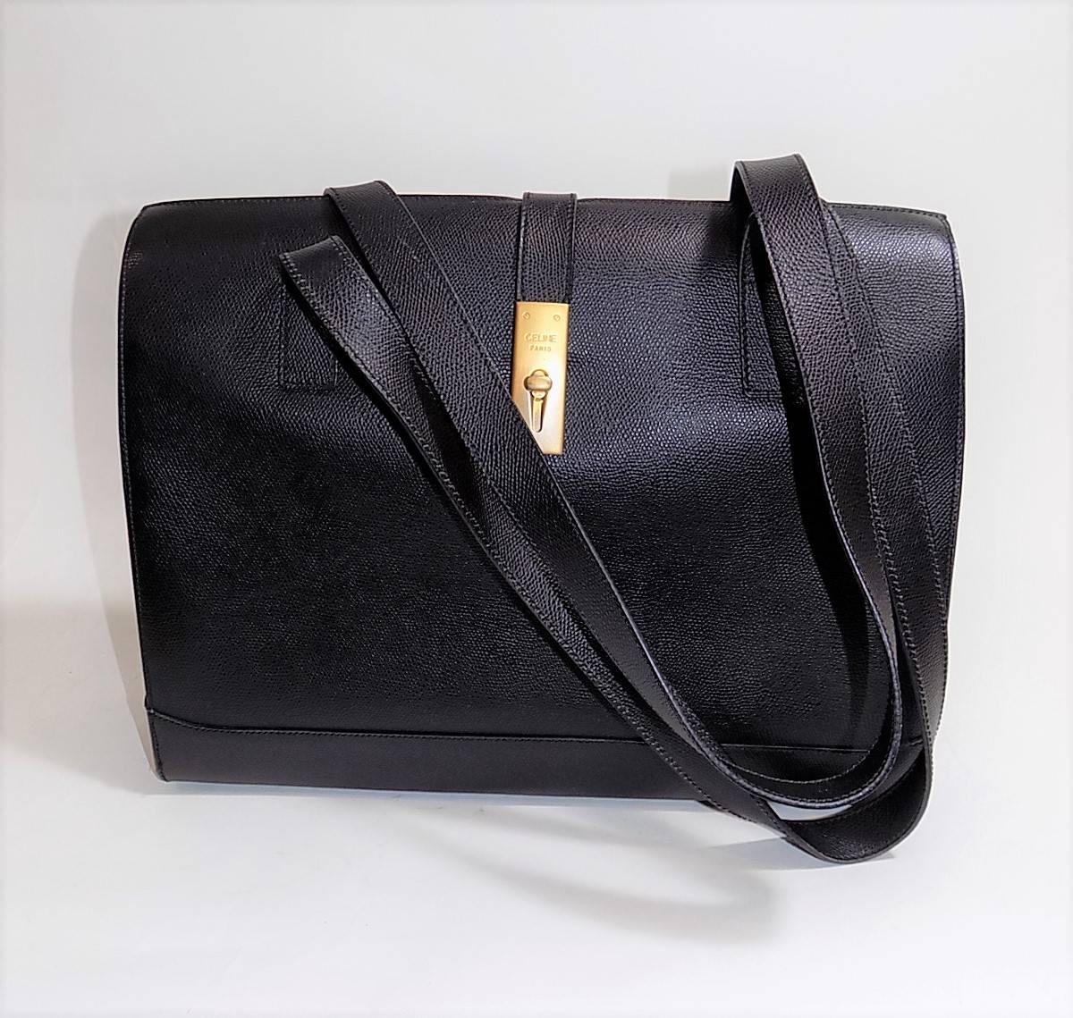 A must have for every power woman out there!!!!!. Black leather Celine hard sides briefcase. Gold tome brushed Celine lock front. Protective bottom feet. Two long shoulder straps. . When open it shows striking red supple leather lining. One large