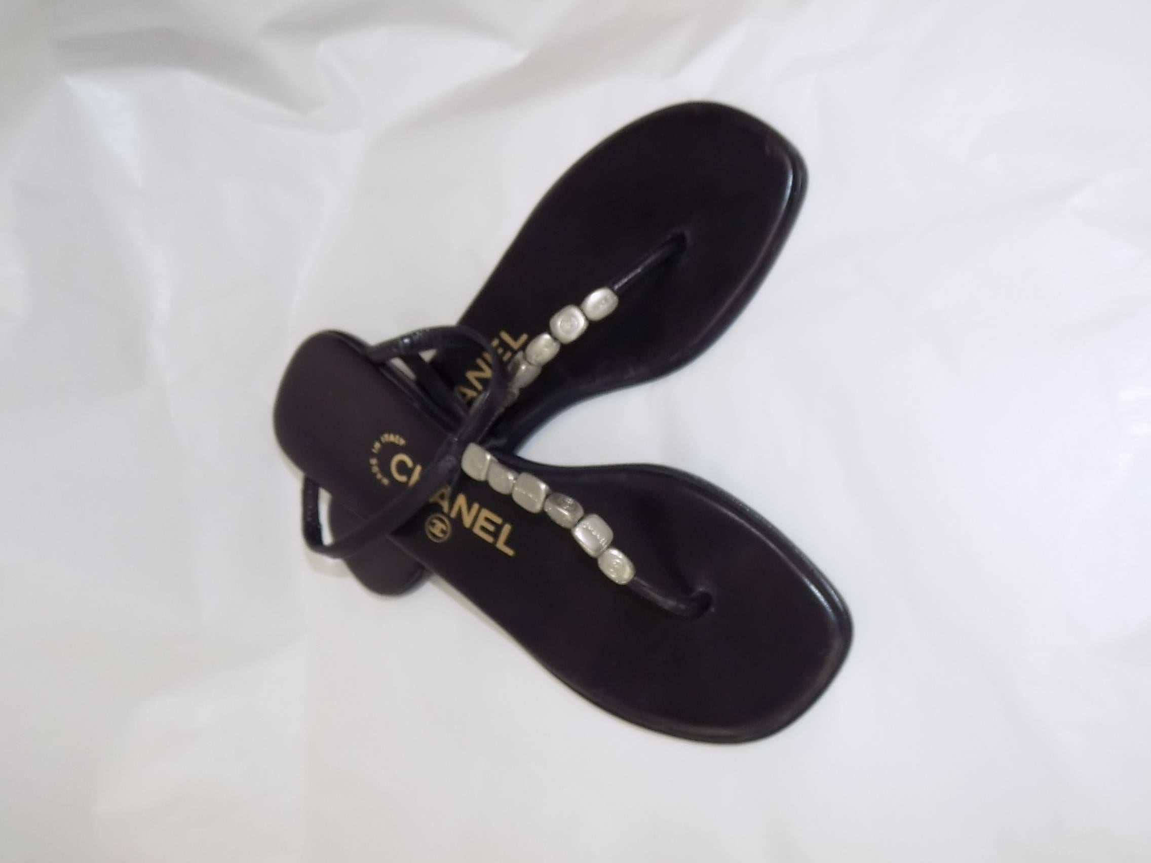 Black leather Chanel thong sandals with silver-tone logo charmes sz 35 In Excellent Condition In New York, NY