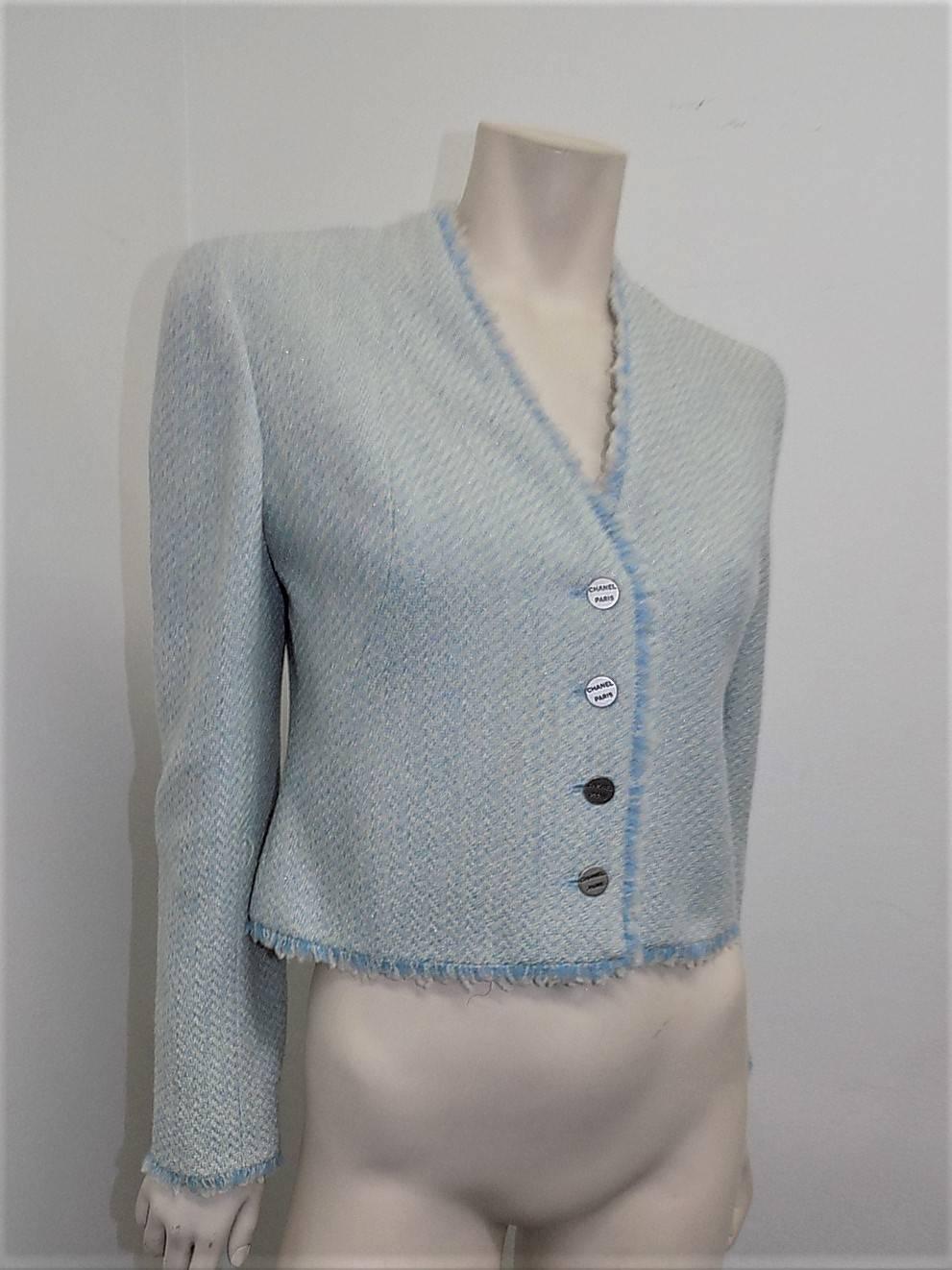 Truly beautiful and very versatile lite blue with silver speckles Chanel cropped jacket . Featuring fringed trim,  large silver metal engraved buttons and bolero style v  vent  back cut. Silk lined in pristine condition. Perfect for evening or just