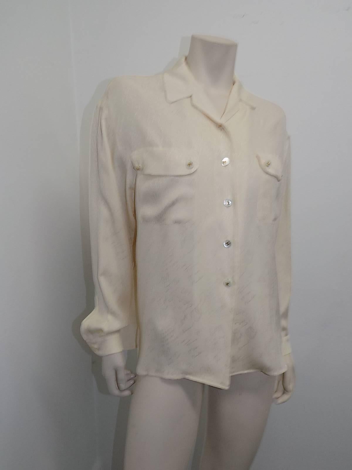 Incredible Chanel Rare Vintage cream silk Jacquard  blouse shirt. Featuring  MOP buttons with gold tone CC logo, two patch pockets with flap and buttons, collar , cuffed sleeves and most important amazing Coco Chanel motif  Jacquard  print. From her