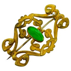 Antique 1920s gold tone filigree ornate oval green glass cabochon brooch