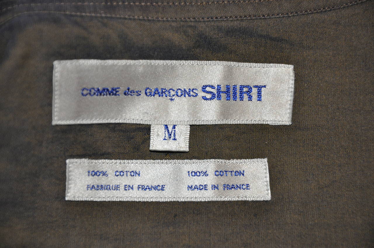 Comme des Garcons men's olive-green shirt is accented with embroidered patch pocket in front.  100% cotton, size medium/France.
   The shoulder measures 20