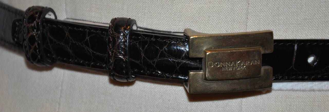 Cette ceinture en cuir de veau gaufré brun coco est ornée de la boucle nominative signée Donna Karan. La ceinture mesure 5/8