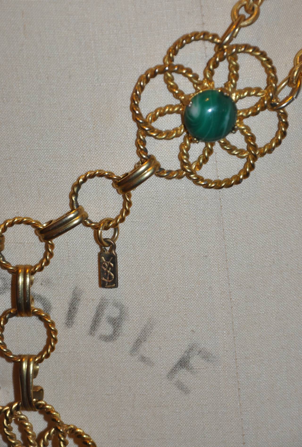 This wonderfully detailed rare Yves Saint Laurent multi-stones in colors of greens, and browns is combined with gilded gold hardware and finished with their signature engraved name-plate attached. The belt measures 2 1/8