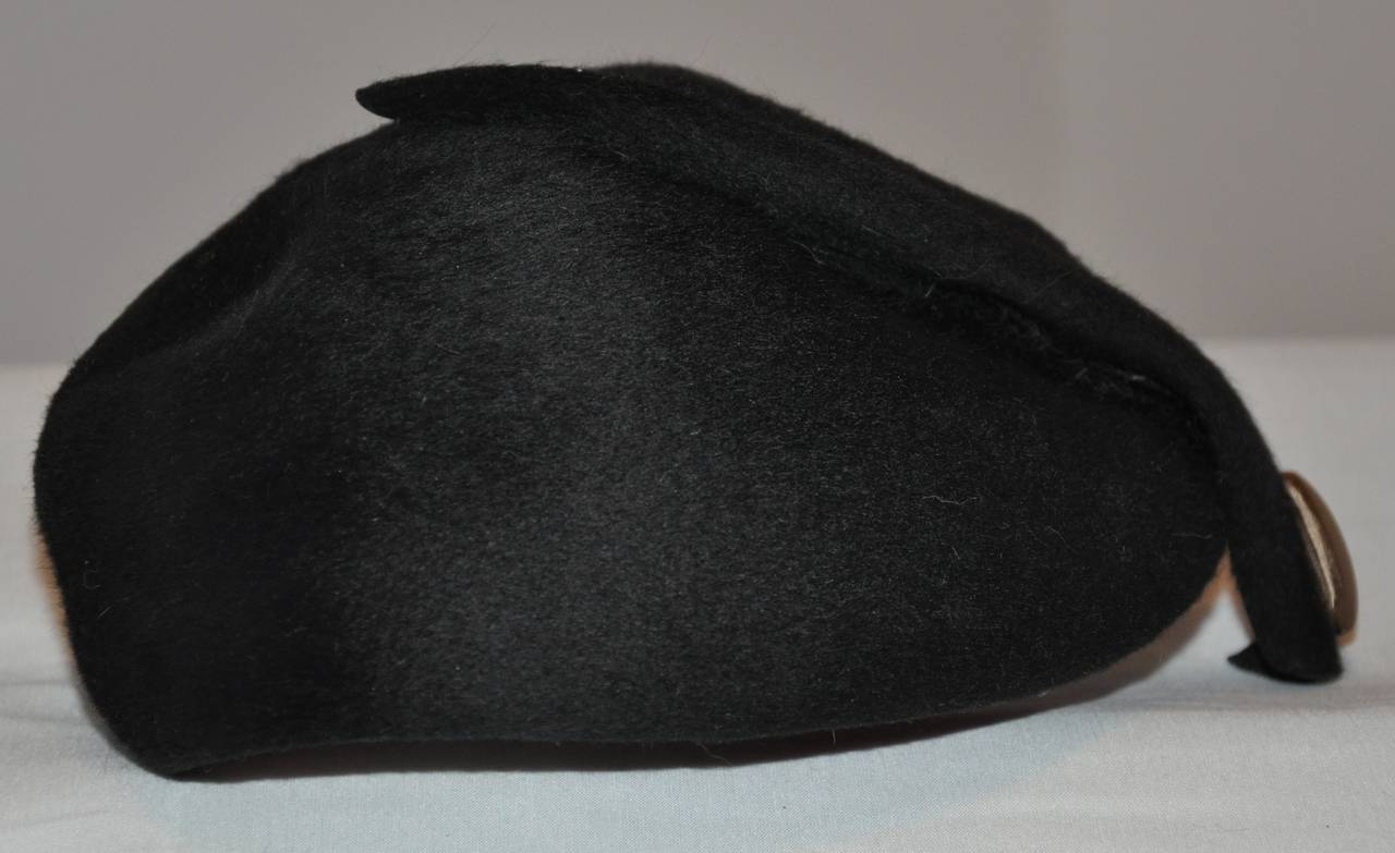 Mr. John wonderfully detailed black brushed wool felt cloche is accented with a tail-like finished with a bronzed silk-covered button. The tail-like measures 10 3/4" in length. the circumference measures 25", height is 4 1/2".