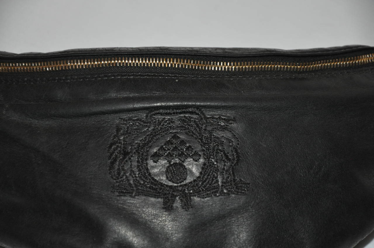 L'astuccio in pelle d'agnello nera di Bottega Veneta è impreziosito dal logo inciso sul davanti. Il marsupio è abbinato a ferramenta e attacchi dorati. Entrambe le estremità della ferramenta dorata possono essere rimosse quando lo si desidera. La