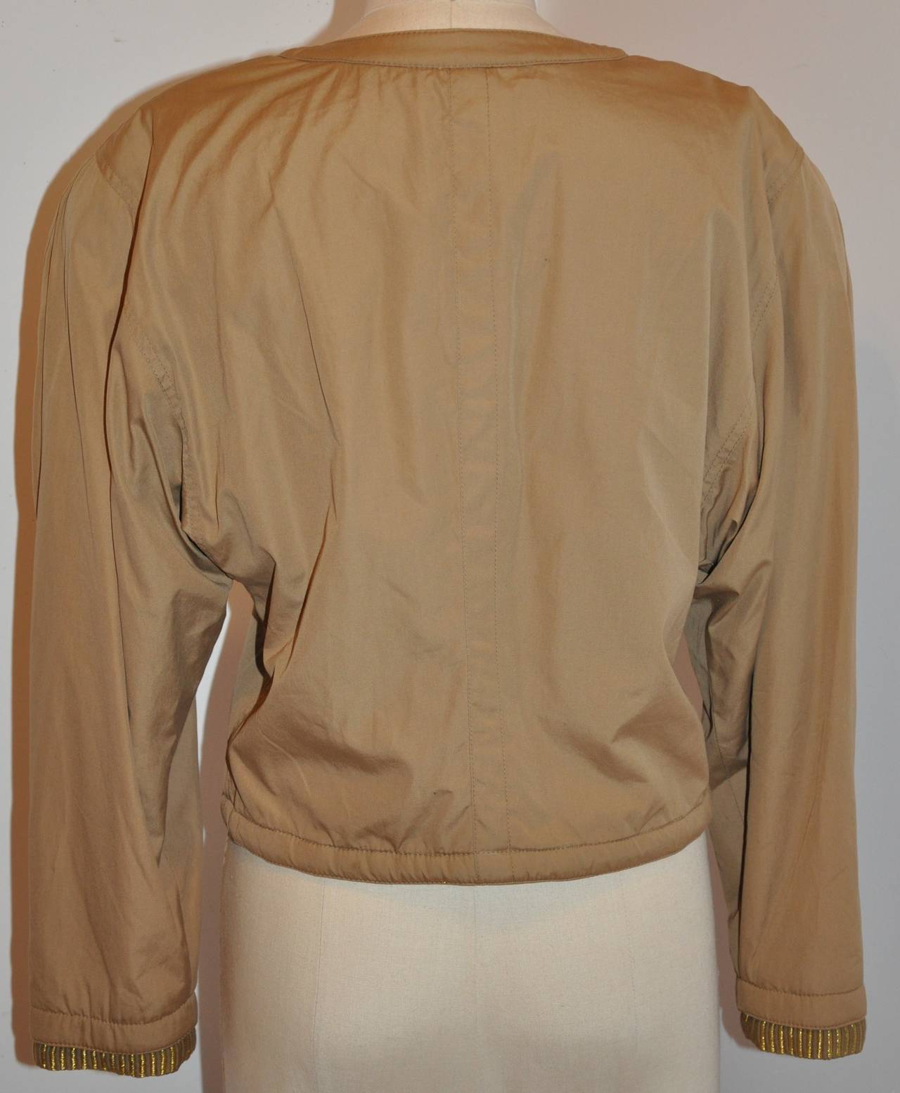 This wonderfully rare detailed Callaghan taupe cropped buttoned jacket is highlighted with a woven combination of taupe and gold lame lining along with detailed hand-embroidered gold lame on the center front and sleeve's cuffs.
   Shoulder are