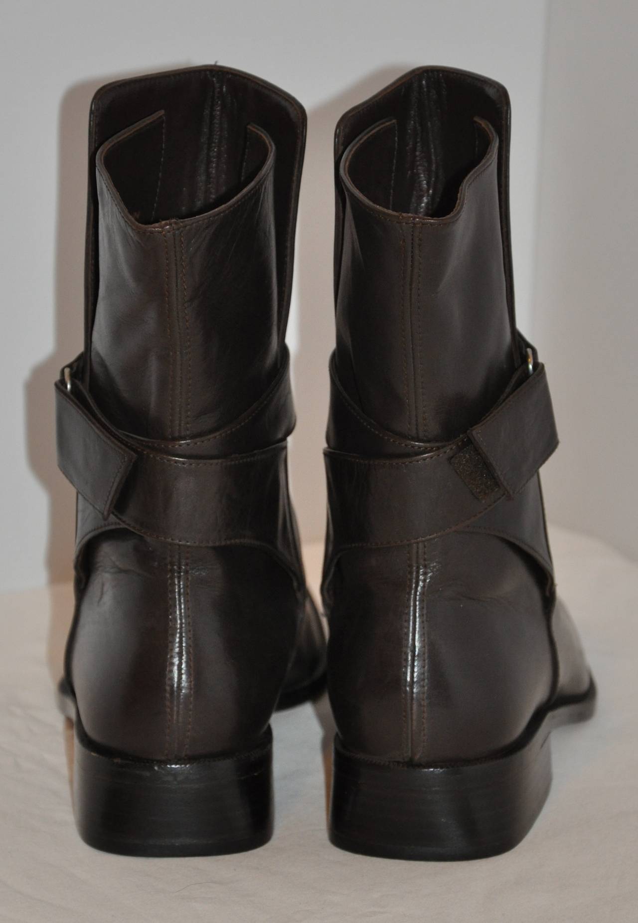 Jil Sander black calfskin boots features a wrap-around band accenting the fine workmanship of Jil Sander. The interior has a elastic band for easier fit. The exterior band can be adjusted with the Velcro attachment. Sized 38 1/2 European, 8 1/2