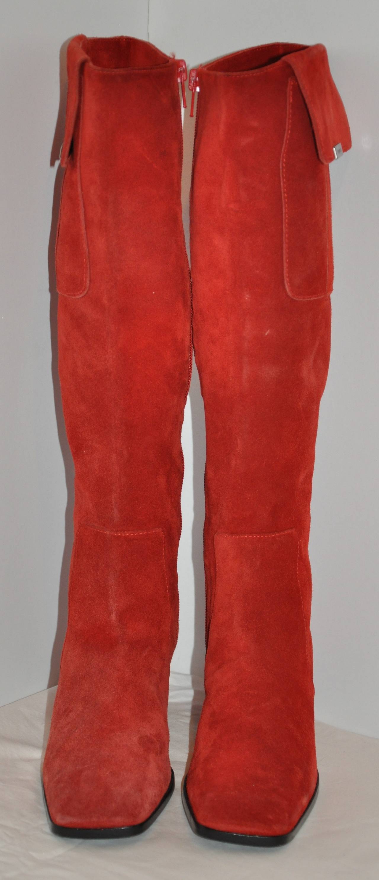 Yves Saint Laurent bold red brush suede high boots is accented with a side patch pocket on each side of these wonderful boots. The patch pockets are detailed with their signature name logo engraved on gold hardware on each and finished with a snap