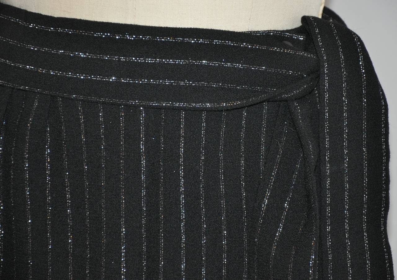 Der Wickelrock von Jaeger aus schwarzem Woll-Crêpe ist mit silberfarbenen Metallic-Lamé-Streifen akzentuiert. 99% schwarzer Woll-Crêpe & 1% silberfarbenes Metallic-Lamé. Der Wickelgürtel wird mit einem optionalen Bindegürtel geliefert, der 2