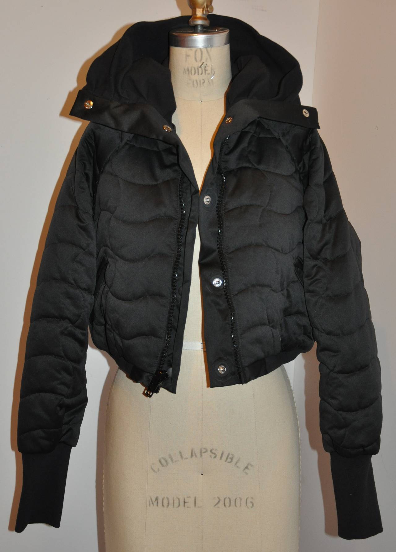 Stella McCartney wicked extreme high-collar black quilted cropped puffer zipper jacket has the options to use the interior snaps located underneath the front zipper. There are two front set-in pocket with detailed small flat pleats near the arms