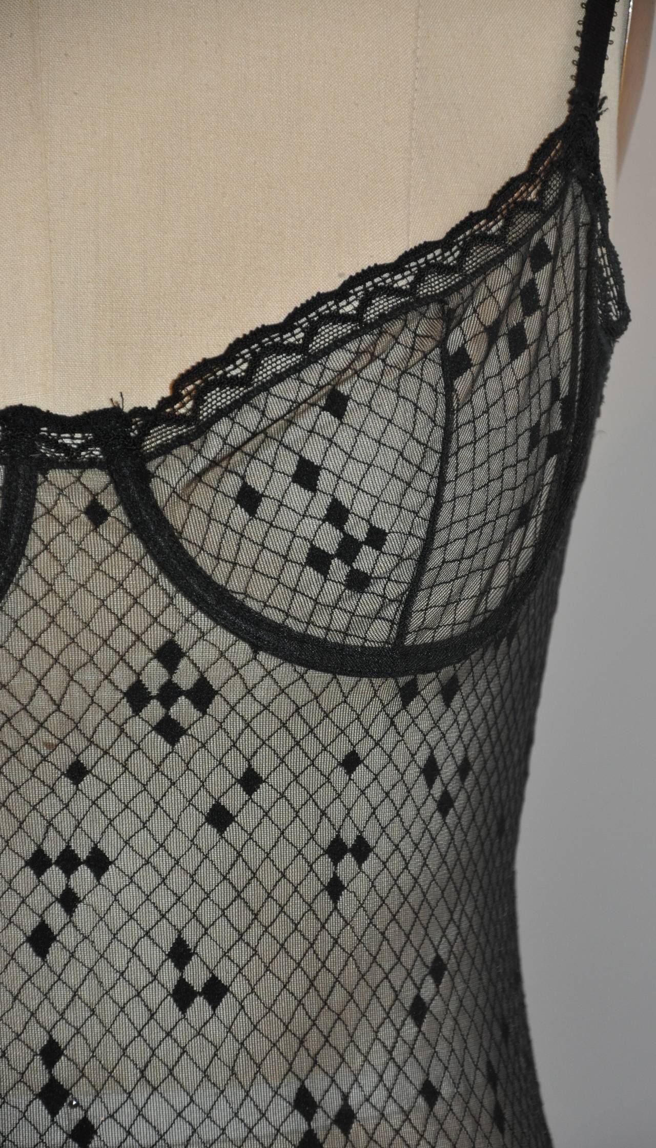 El body de encaje negro con aros ERES es de talla 40/Francés. Hay tres corchetes opcionales en la entrepierna para un mejor ajuste al llevarla puesta. Los bordes están acentuados con un acabado de cinta de encaje. Fabricada con elastano y encaje de