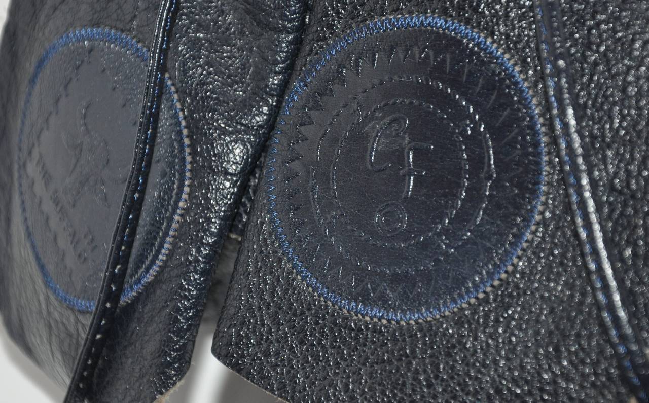 Le sac à bandoulière en peau de buffle texturée Carlos Falchi, de couleur bleu nuit, est doté d'un cordon intérieur permettant d'ajuster les bretelles si nécessaire. L'intérieur comporte deux compartiments séparés, dont l'un est doté d'un