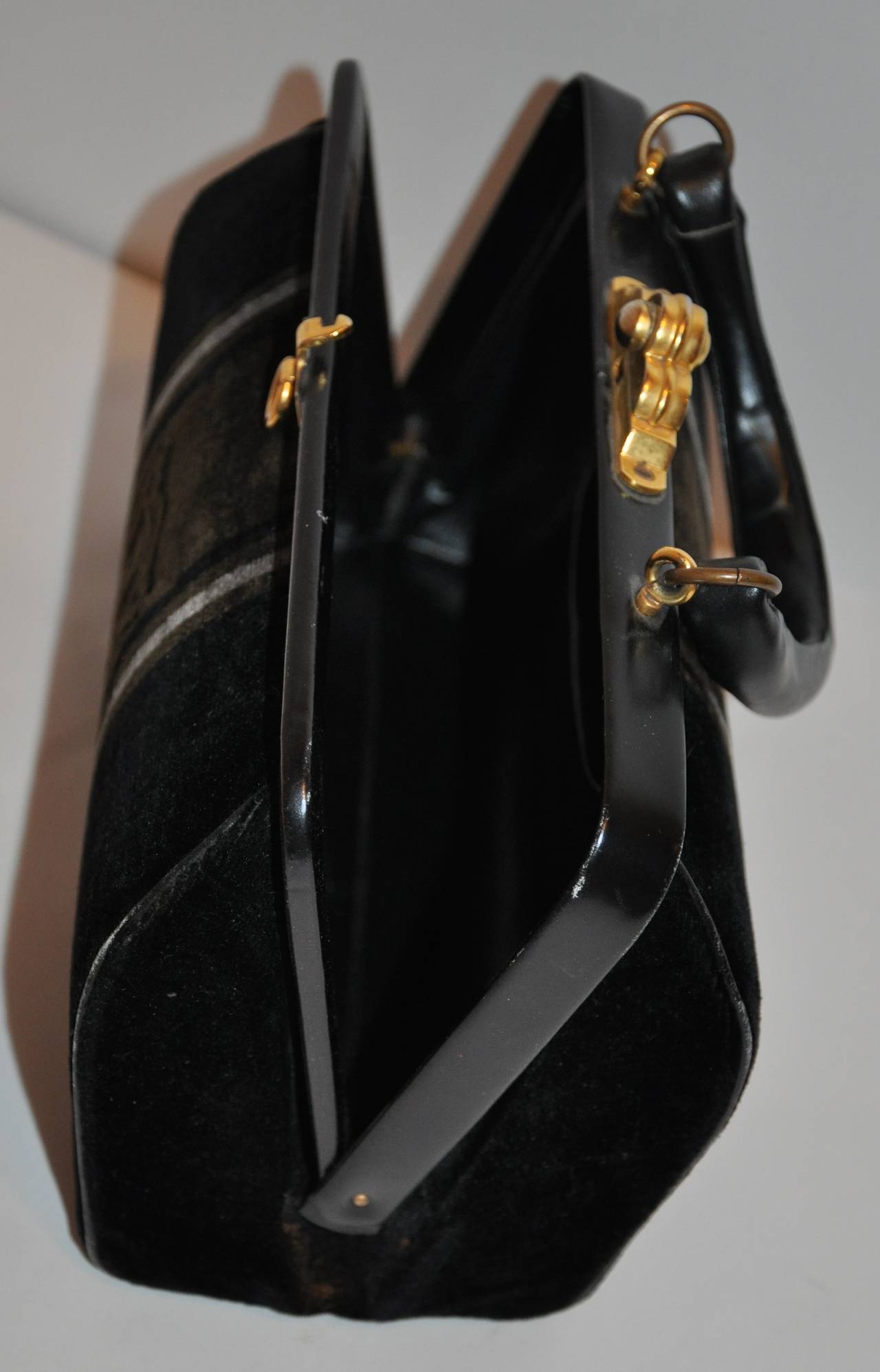 Roberta di Camerino's wonderfully plush cotton black velvet with gray stripe handbag has a heavy hard frame, along with detailed thick gold hardware clasp and opening to this wonderfully elegant and classic work of art in this handbag.
     The