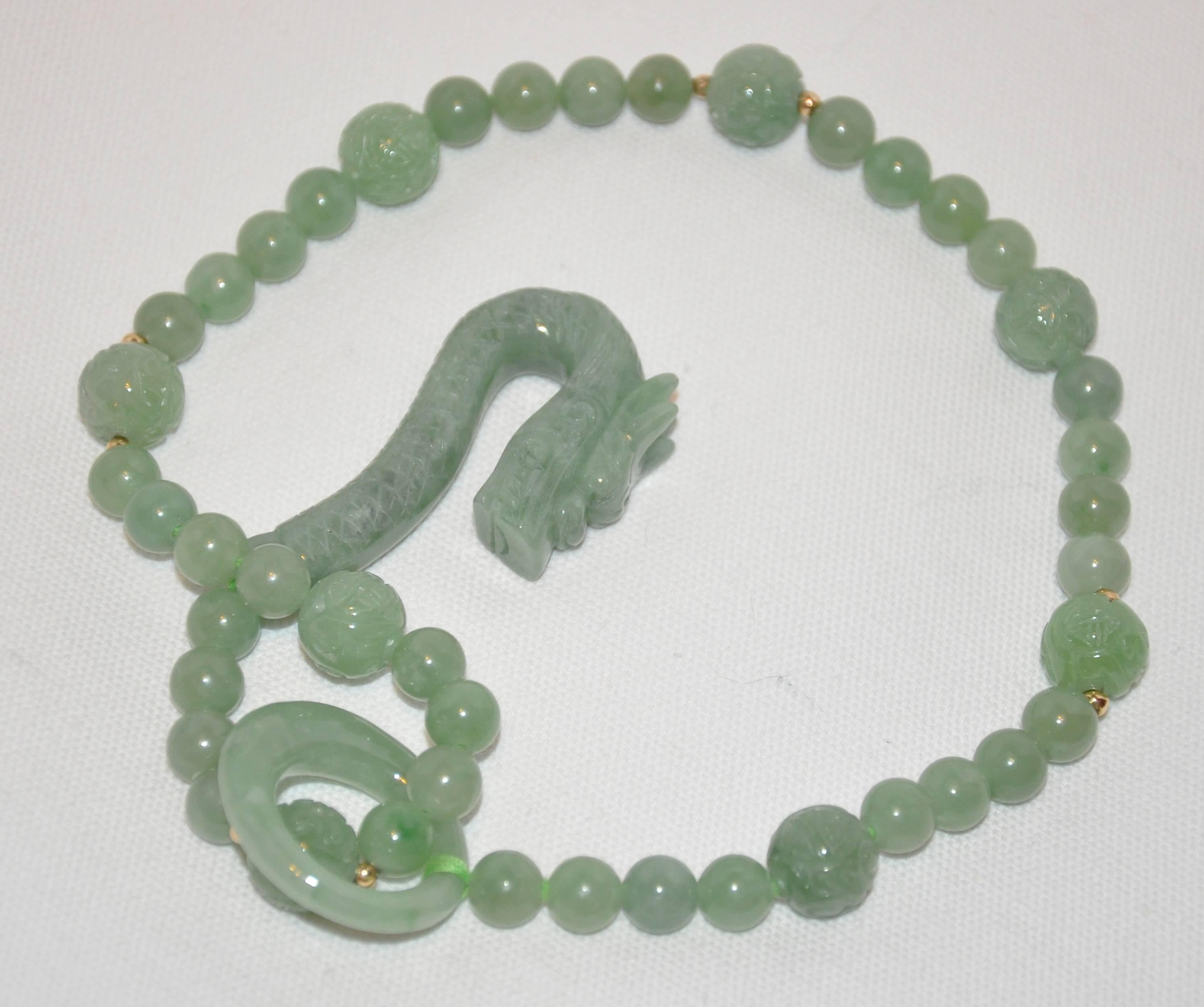        This wonderfully detailed hand-knotted jadeite necklace is feature with a dragon-head which drapes on the end and a loop on the other beautifully hanging. This beautiful necklace is hand-knotted and measures 19" in total length. The
