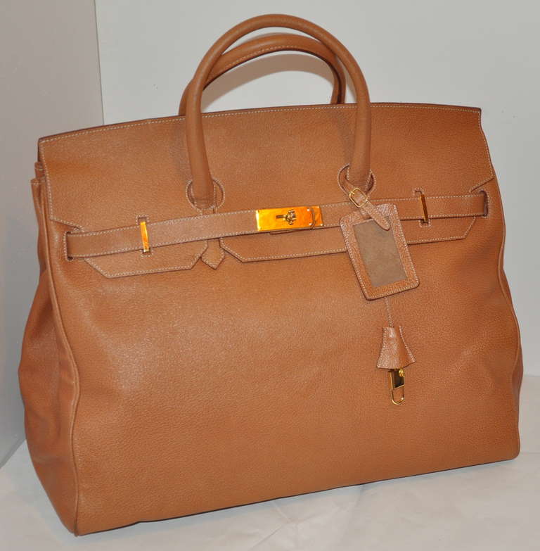 This wonderful Siso huge textured calfskin weekend tote bag is accented with gilded gold hardware along with a lock & key and also a removeable leather name tag for traveling.
   The flap measures 6 1/4