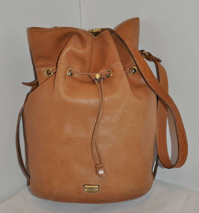 This buttery soft lambskin tan leather hobo shoulder bag is accented with ostrich straps along the sides. 