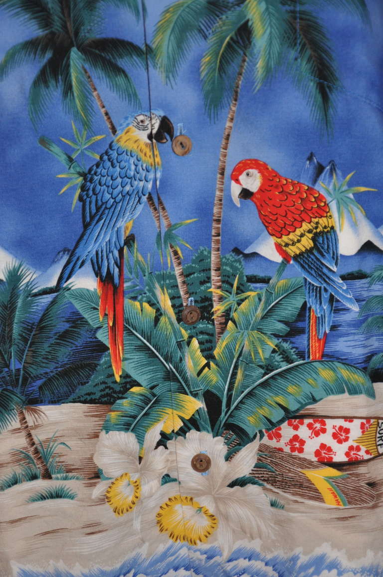 Made in Hawaii, this wonderfully made shirt with tropicial birds and surf boards along both front and back, has a carefully stitched breast pocket in front. There are two small flat pleats on back.
   The front measures 27