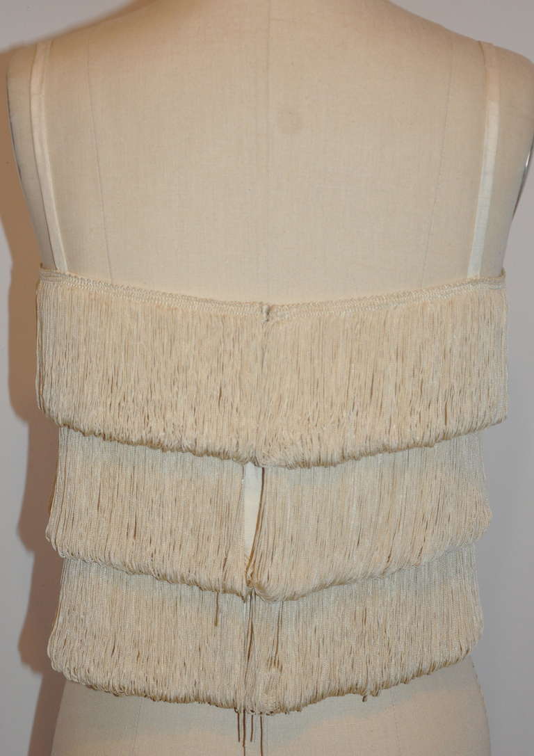 Cream multi-tier fringed top has a center-back snap-n-hook closing. Back length measures 9