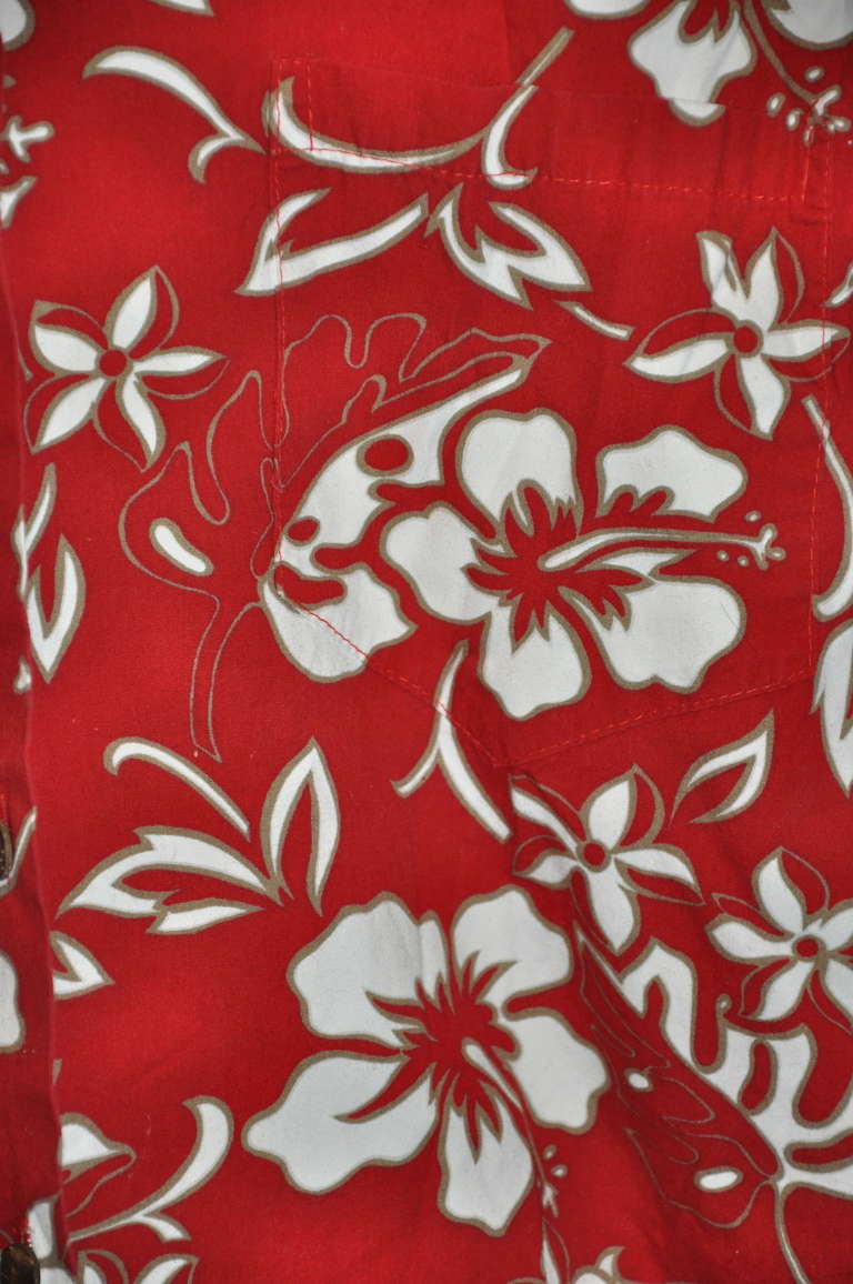 Made in Hawaii, Hilo Hatties's bold red floral men's shirt with Hawaii's flower print has a single breast pocket in front. 
   The front measures 24