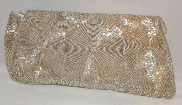 Schildkraut Bros. swirls of silver glass micro bugle beads evening clutch is fully lined with silk. The opening has a snap closing. 
   Evening clutch measures 9