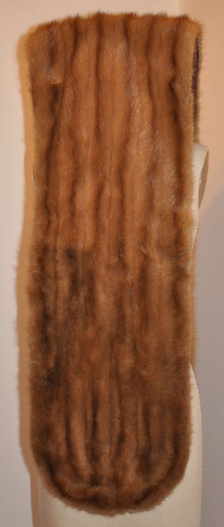 This wonderfully fully lined warm-brown female-skins mink has curved borders. Can be worn as a wrap, as a scarf or just over one shoulder. Versatile and just lovely for a finishing touch to any ensemble.
   Scarf measures 77