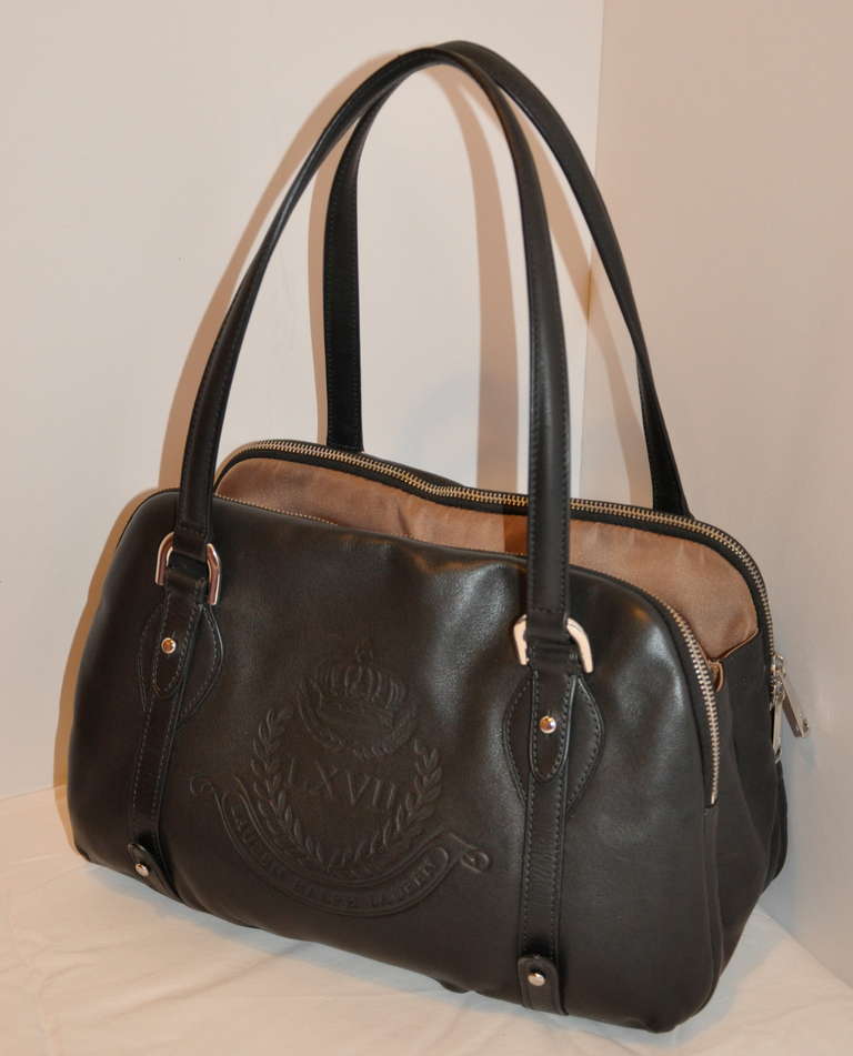 This wonderfully thought-out tote handbag from Ralph Lauren has three sectional compartments. The two outer sections has a double-zipper opening, with options of using the zipper from the front, back or at the center top. The center section has a