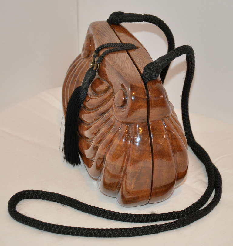 Jimmy Woods of Beverly Hills warm-brown hand-carved wooden evening bag is fully cushioned and lined with black silk, along with a zippered compartment. This wonderful bag can be worn as a clutch with the hand-woven black silk cord neatly tucked