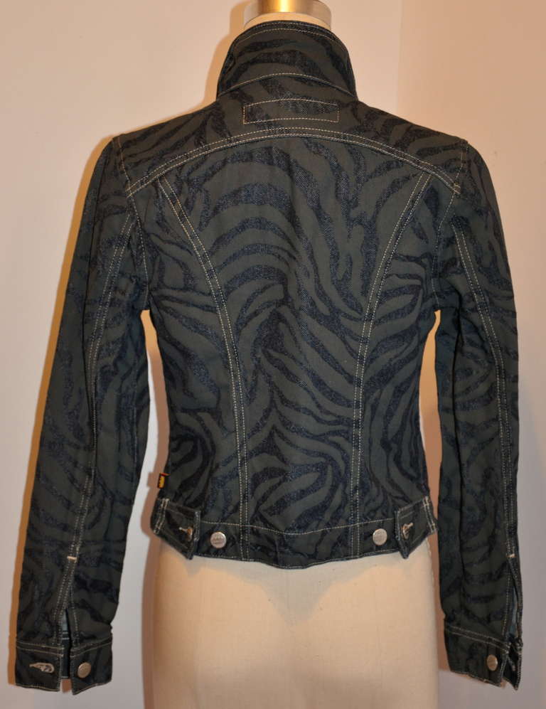 Todd Oldham black and navy leopard print jacket is accented is silver hardware studd buttons engraved with Todd Oldham. Front has six (6) buttons along with two breast pockets finished with a single hardware button on each.
   Collar stands at 2
