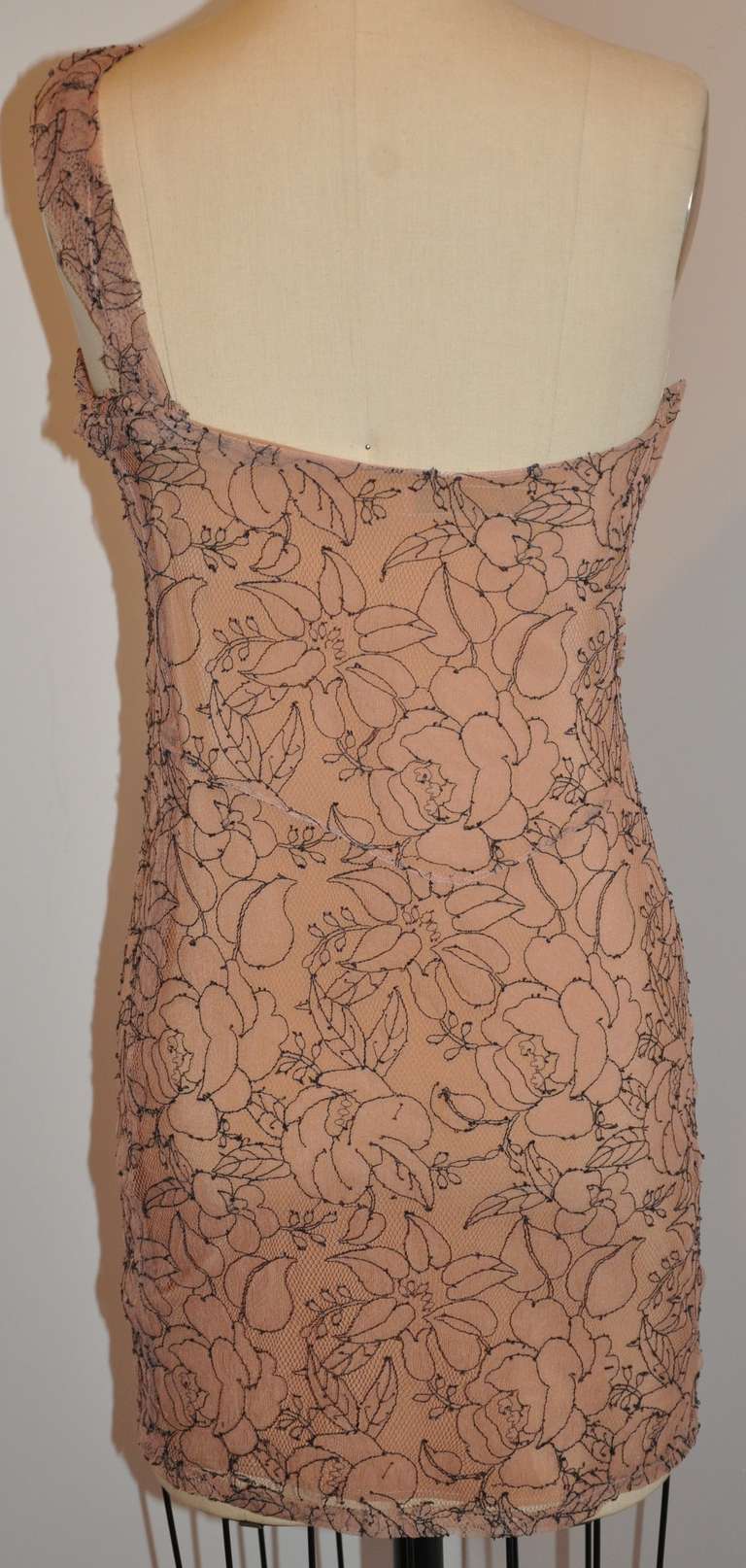 This wonderfully wicked, yet elegant Christian Dior cocktail dress from his 'Boutique' collection is fully lined with silk. There are 30 fabric-covered micro buttons covering the invisible zipper which measures 13