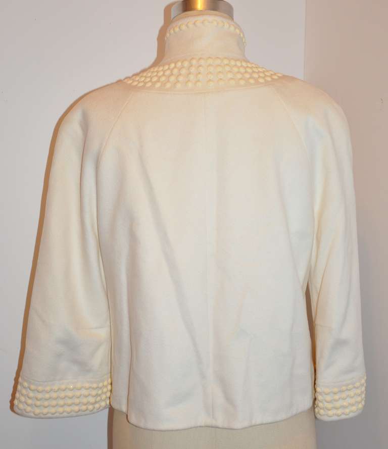 This wonderful winter white cashmere jacket is fully lined with silk crepe de chine. The exterior has two side set-in pockets hand-embellished with cream-colored beads matching the same hand-embellished beads throughout the jacket.
   The front of