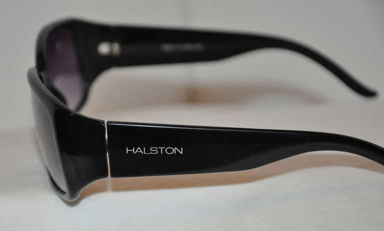 Halston black lucite sunglasses by N.Y. Colors in Optics, Itd. comes along with a case.
   Height measures 1 6/8